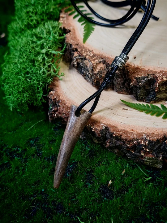 Ręcznie wykonany wisiorek z naturalnego fragmentu poroża sarny. Prosty, smukły kształt oraz stonowana, naturalna powierzchnia nadają mu surowy, leśny charakter.