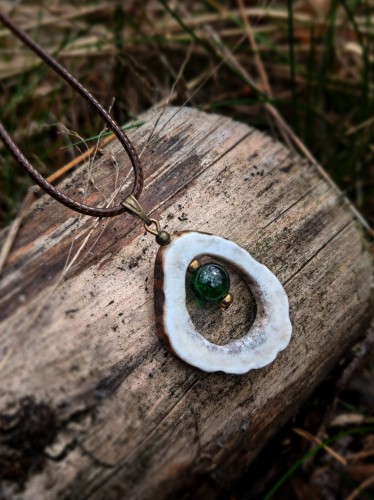 Ręcznie wykonany wisiorek z naturalnego poroża jelenia, starannie wycinany i szlifowany w organiczny, owalny kształt.